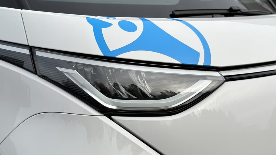 Detaljefoto av en grå varebil med blå firmadekor